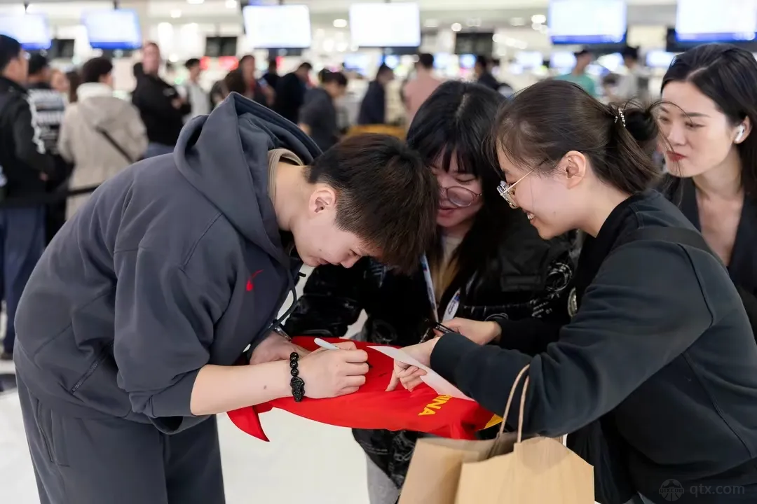 中国女篮球员回国在机场给球迷签名